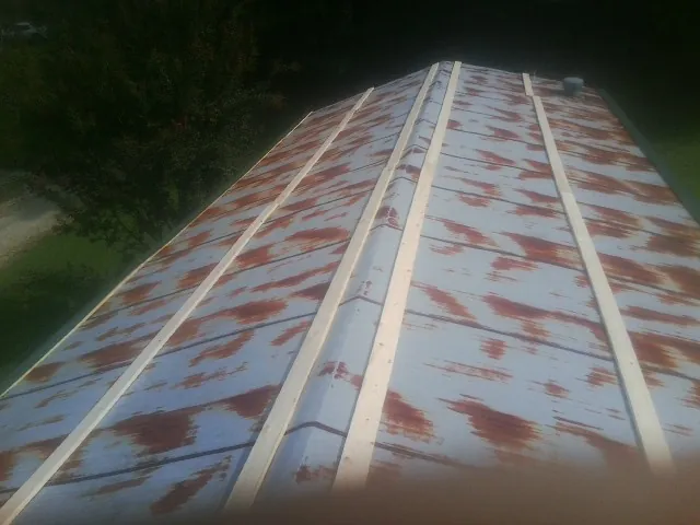Rusted metal roof panels with new wood purlins before replacement — Storm Damage Roof Repair in Carrollton by Roofing Brothers